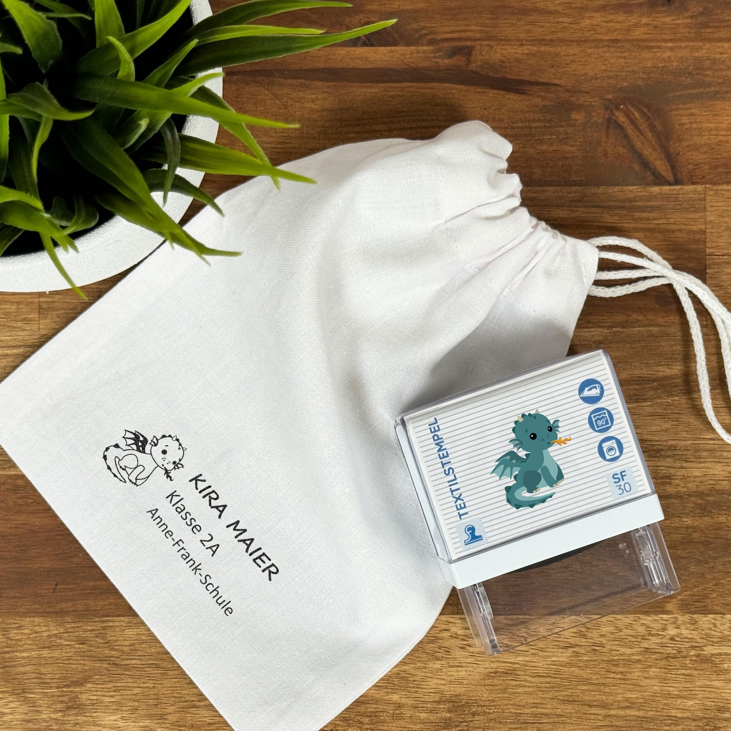 Textilstempel für Kinder mit Drache-Motiv, personalisierbar, 47x18 mm, von stempel-fabrik.de, zeigt den bunten Kinder-Textilstempel