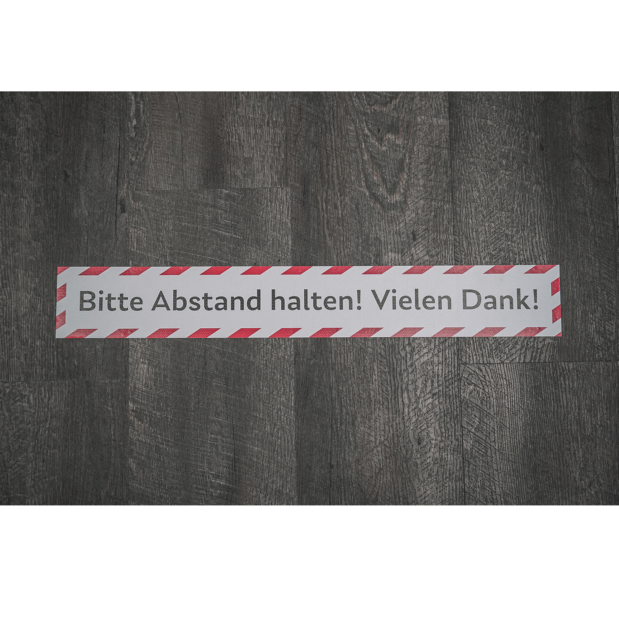 Fußbodenaufkleber 700x100 mm mit "Bitte Abstand halten! Vielen Dank!" in Schwarz auf transparentem Hintergrund